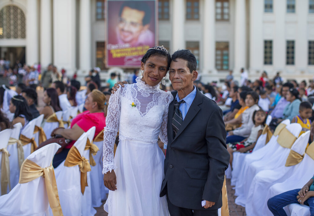 A couple poses for a photo after participating in a mass wedding in Managua, Nicaragua, Tuesday, Feb 14, 2023. (AP Photo/Inti Ocon)