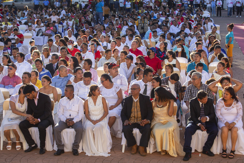 Couples sit together during a mass wedding in Managua, Nicaragua, Tuesday, Feb 14, 2023. (AP Photo/Inti Ocon)
