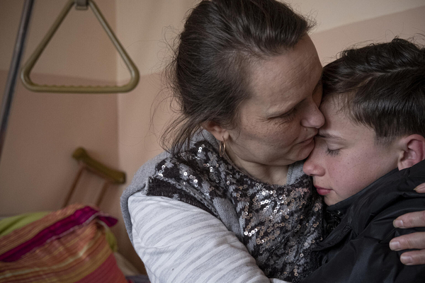 On 17 April 2022 in Chernihiv, Ukraine, Danylo, 12, and his mother, Liudmyla, 39, embrace as he visits her in the hospital for the first time since she was injured a month ago, by flying shrapnel when their home was hit during fighting. Their village – and specifically their street – was a site of fierce fighting for over a month, and today the area is almost completely razed. “Before the war, I didn’t know any of the sounds of fighting,” says Danylo. “Now I can hear the difference between missiles and shelling, or outgoing and incoming.” 

Danylo remained at home during the siege with Liudmyla and his grandmother, Nina. Liudmyla remains in the hospital where surgeons initially fought to save her life and continue to fight to save her foot, which may need to be amputated. Their cat, Lyzunia (Ukranian for ‘the one that licks’), was hit by shrapnel in her shoulder and had her whiskers burnt off. On 21 March, the family’s house was destroyed and burnt during fighting. Danylo and his grandmother had fled three days earlier, and today live at the home of a family that temporarily took them in. “They’re not relatives and we don’t know what’s going to happen,” says Nina, her voice shaking. “We have nowhere to go, and Danylo’s mother is about to get out of hospital. We don’t have money, we don’t even have food. It all burnt … This is like a bad, bad dream I never wake up from.”

Danylo cries upon seeing his mother. “I want to raise money to pay for her medical treatments and for her prosthetics.”

Since the escalation of the war in Ukraine starting on 24 February, Chernihiv, close to the border with Belarus, was under siege, leaving the city with no running water, food, electricity or communications. Aerial bombardment and shelling destroyed schools, hospitals, homes and bridges. Fighting raged in the suburbs and half of the 140,000 residents risked their lives to escape. Those who remained lived in makeshift bomb shelters for w
