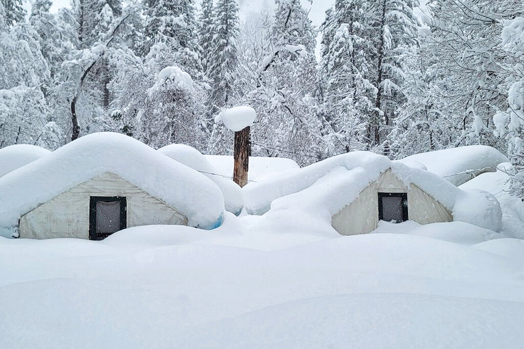 In this photo provided by the National Park Service, tents at Curry Village are covered with snow in Yosemite National Park, Calif., Tuesday, Feb. 28, 2023. The park, closed since Saturday because of heavy, blinding snow, postponed its planned Thursday, March 2, 2023, reopening indefinitely. (National Park Service via AP)