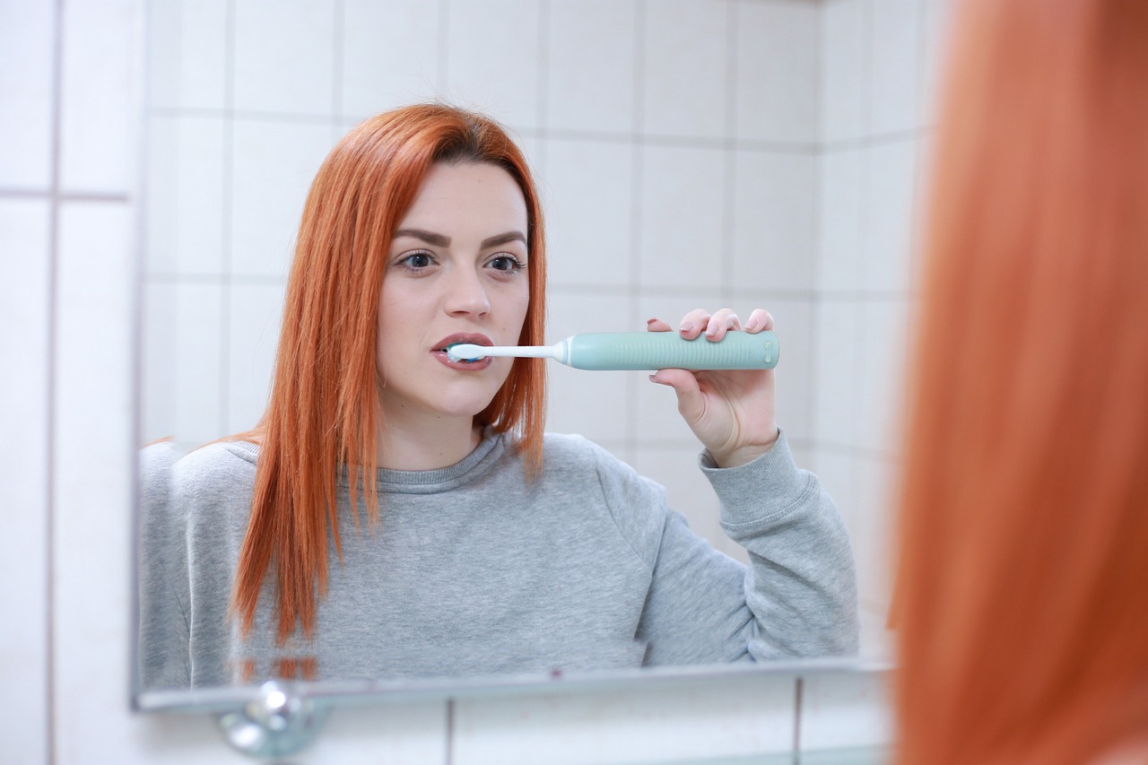Una donna lava i denti. Foto di Martin Slavoljubovski da Pixabay