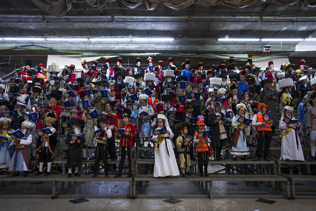 Jewish ultra-Orthodox children wearing costumes as they celebrate the Jewish festival of Purim at a synagogue in Bnei Brak, Israel, Monday, March 6, 2023. The Jewish holiday of Purim commemorates the Jews' salvation from genocide in ancient Persia, as recounted in the Book of Esther. (AP Photo/Oded Balilty)