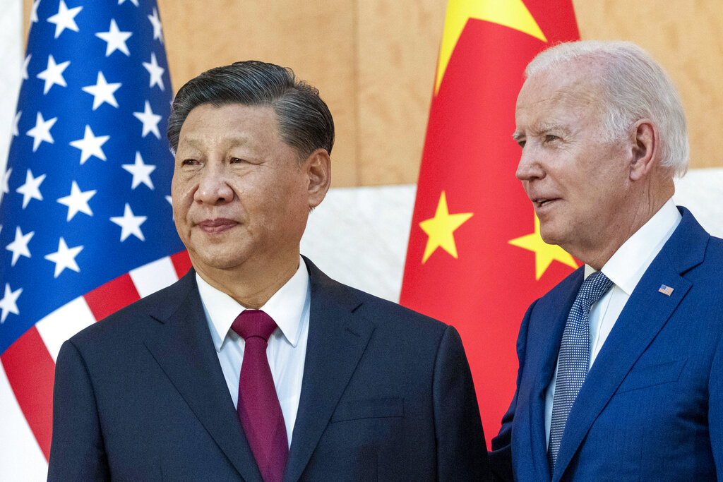 FILE - U.S. President Joe Biden, right, stands with Chinese President Xi Jinping before a meeting on the sidelines of the G20 summit meeting on Nov. 14, 2022, in Bali, Indonesia. Xi accused Washington on Monday, March 6, 2023, of trying to isolate his country and hold back its development. That reflects the ruling Communist Party's growing frustration that its pursuit of prosperity and global influence is threatened by U.S. restrictions on access to technology, its support for Taiwan and other moves seen by Beijing as hostile. (AP Photo/Alex Brandon, File)