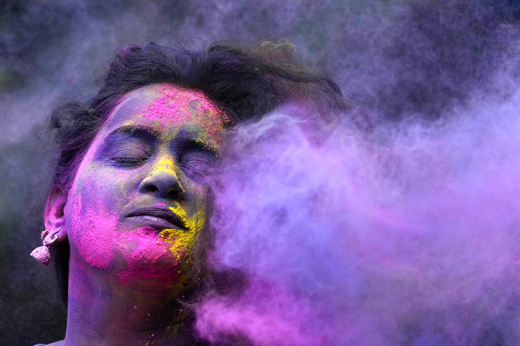A woman smeared with colors play Holi, the Hindu festival of colors, in Mumbai, India, Tuesday, March 7, 2023. The festival heralds the arrival of spring. (AP Photo/Rajanish Kakade)