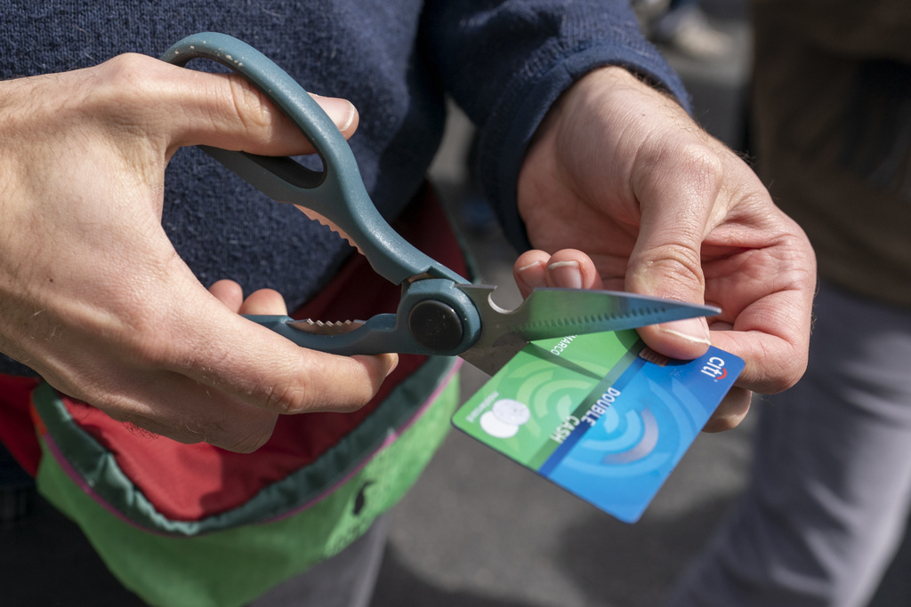 An activist cuts a credit card during a 