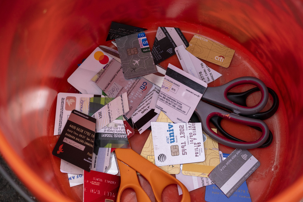 Cut up credit cards and scissors are in a bucket during a 