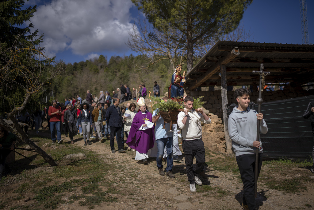 Local residents take part in a procession carrying a replica of the Our Lady of the Torrents, a virgin historically associated with drought, in l'Espunyola, north of Barcelona, Spain, Sunday, March 26, 2023. Farmers and parishioners gathered Sunday at the small hermitage of l'Espunyola, a rural village in Catalonia, to attend a mass asking the local virgin Our Lady of the Torrents for rain. Prayers and hymns were offered to ask for divine intervention in solving the earthly crisis. (AP Photo/Emilio Morenatti)