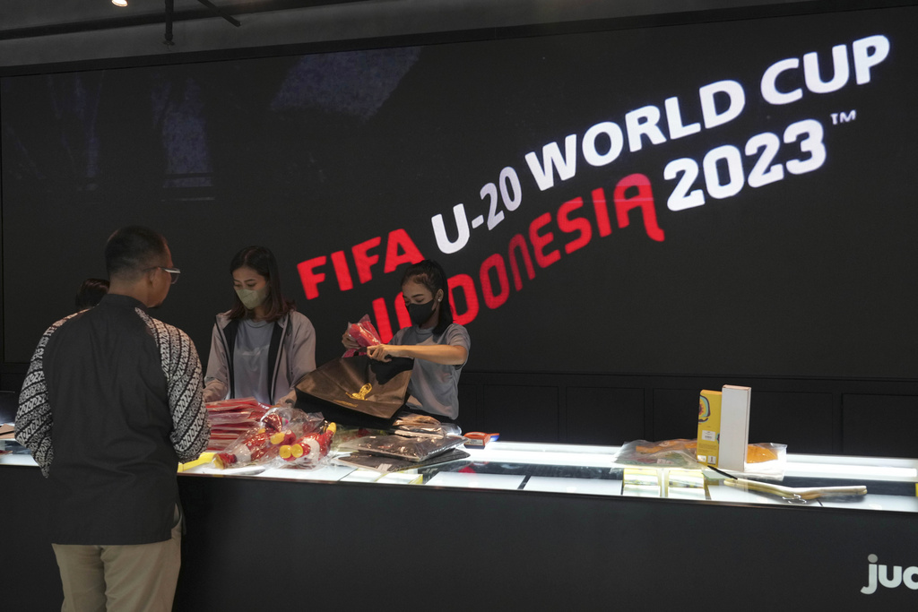 Shop attendants serve a customer who shop for FIFA U-20 World Cup official merchandises at a shopping mall in Jakarta, Indonesia, Friday, March 31, 2023. Indonesian soccer players and fans reacted with tears and outrage after the country was stripped of hosting rights for the Under-20 World Cup only eight weeks before the start of the tournament amid political turmoil over Israel’s participation, leaving Indonesian soccer at risk of further sanctions. (AP Photo/Tatan Syuflana)