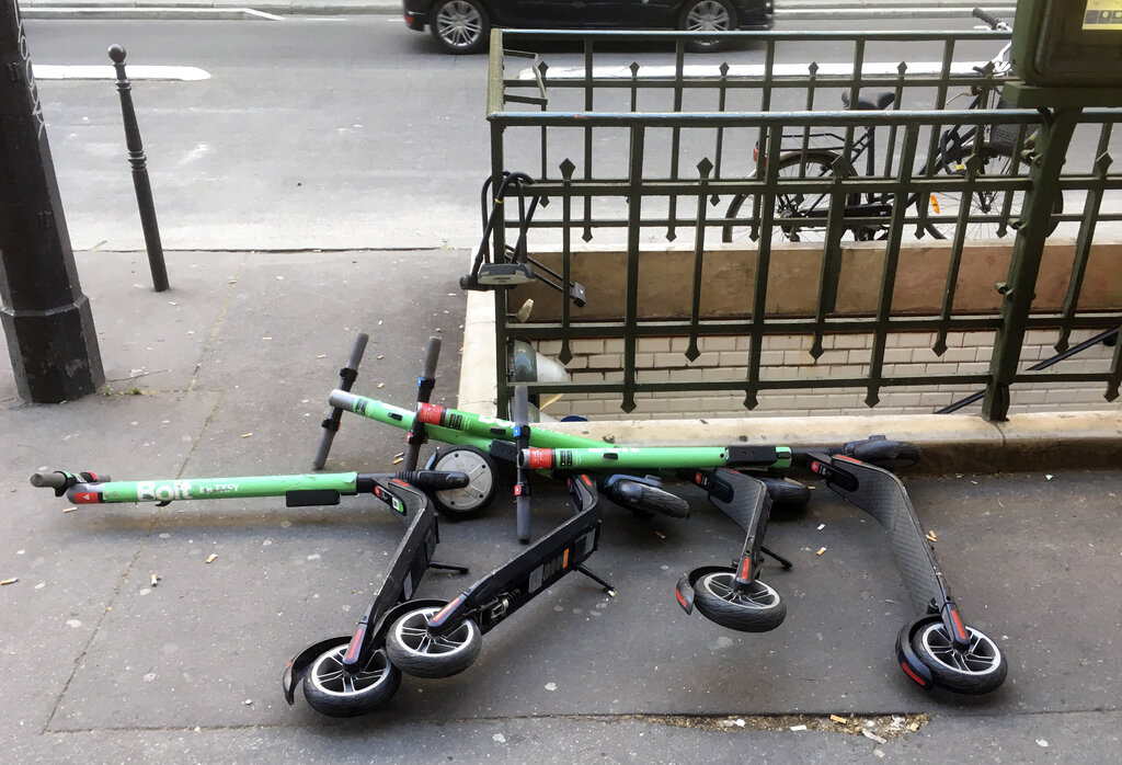 Electric scooters for sharing lay on the sidewalk outside a subway station in Paris, Thursday, March 21,2019. According to the City of Paris, there are 15,000 free-floating vehicles of all forms and shapes in the city, from electric scooters to fluorescent bikes and motorcycle-like scooters. (AP Photo/Bertrand Combaldieu)