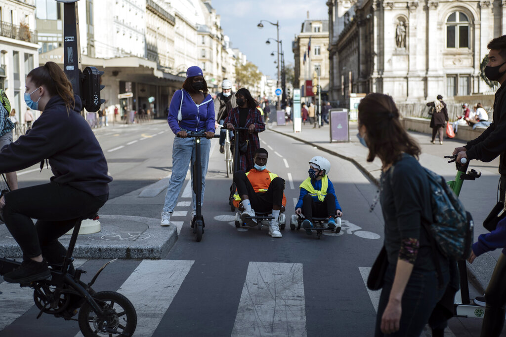People, wearing face masks to prevent the spread of the coronavirus, ride electric scooters, in Paris, Monday, April 19, 2021.(AP Photo/Lewis Joly)