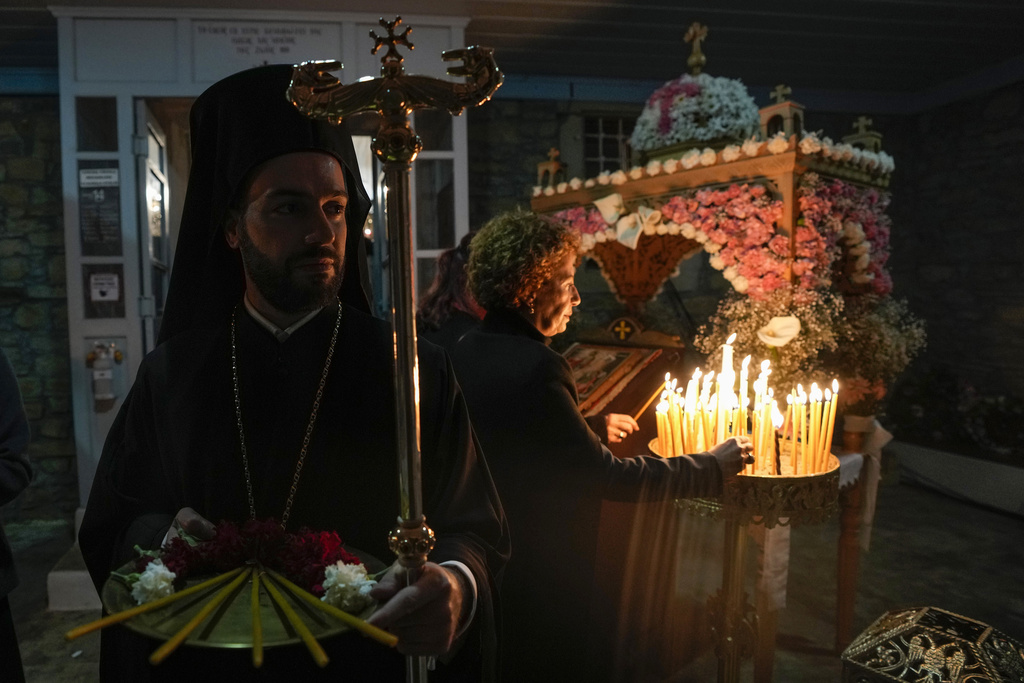 Worshippers hold candles as they attend Mass at the Church of St. George on the island of Gokceada, Turkey, known as Imvros in Greek, Saturday, April 15, 2023. The Ecumenical Patriarch Bartholomew I, based in Istanbul, fulfilled a 10-year promise to mark Easter on the Turkish island where he was born. (AP Photo/Khalil Hamra)