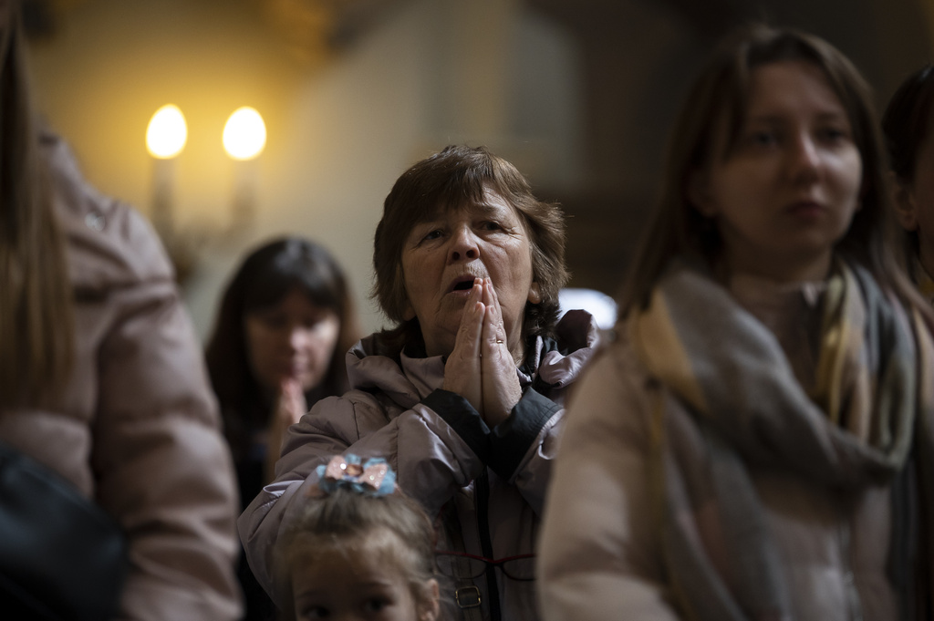Ukrainian refugees pray during a celebration of the Orthodox Easter at the Church of Saint Michael in Hungary's capital of Budapest, Sunday, April 16, 2023. The escalation of the war In Ukraine has been forcing millions of Ukrainians to flee their homes and seeking safety in other countries. According to UNHCR, the UN refugee agency, more than 8 million of Ukrainians have been uprooted since the beginning of the war.(AP Photo/Denes Erdos)