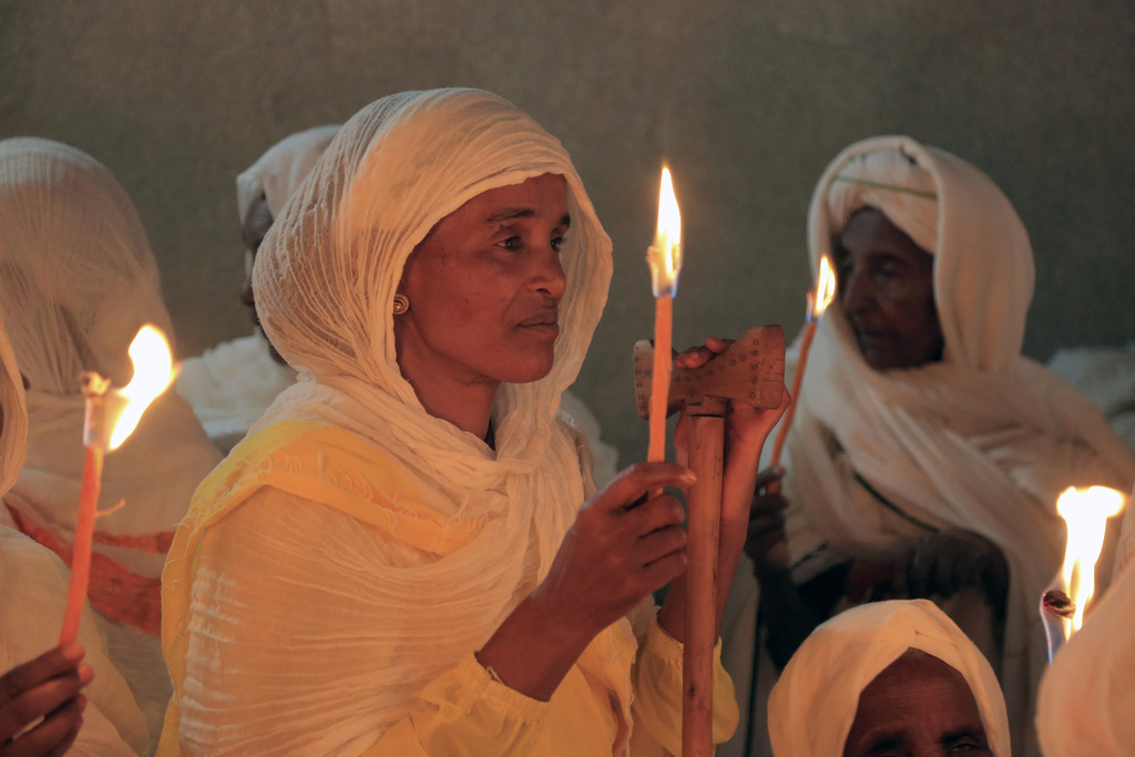 A woman holds a candle during the Orthodox Easter religious procession, in Addis Ababa, Sunday, April 16, 2023. (AP Photo) .