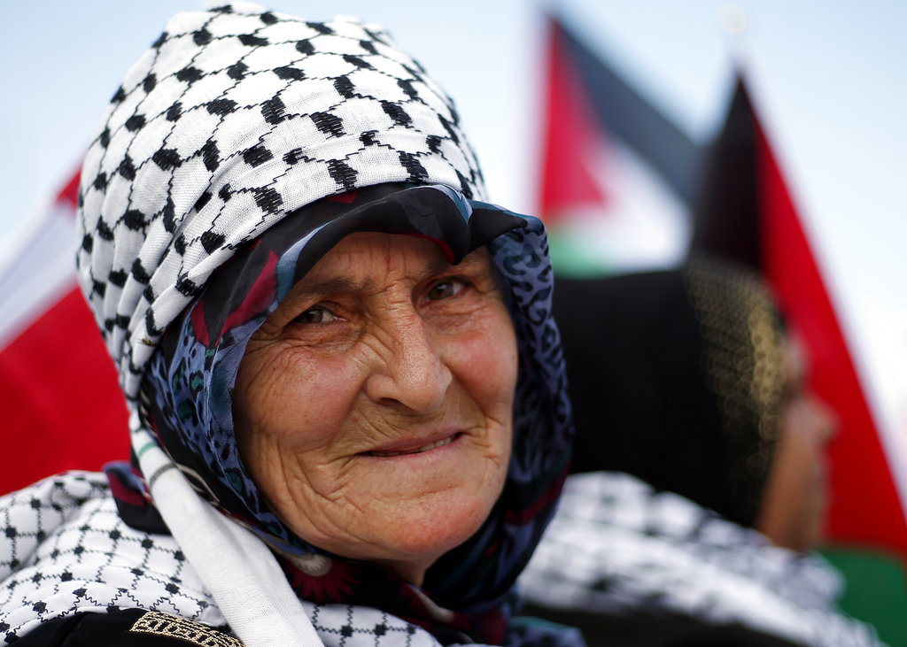 A Palestinian woman living in Lebanon holds a Palestinian flag during a rally to mark the 70th anniversary of what Palestinians call their 