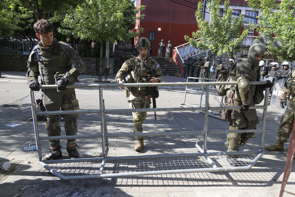 KFOR soldiers set up a security fence in front of a municipal building after yesterday's clashes between ethnic Serbs and troops from the NATO-led KFOR peacekeeping force, in the town of Zvecan, northern Kosovo, Tuesday, May 30, 2023. The violence was the latest incident as tensions soared over the past week, with Serbia putting the country's military on high alert and sending more troops to the border with Kosovo, which declared independence from Belgrade in 2008. (AP Photo/Bojan Slavkovic)