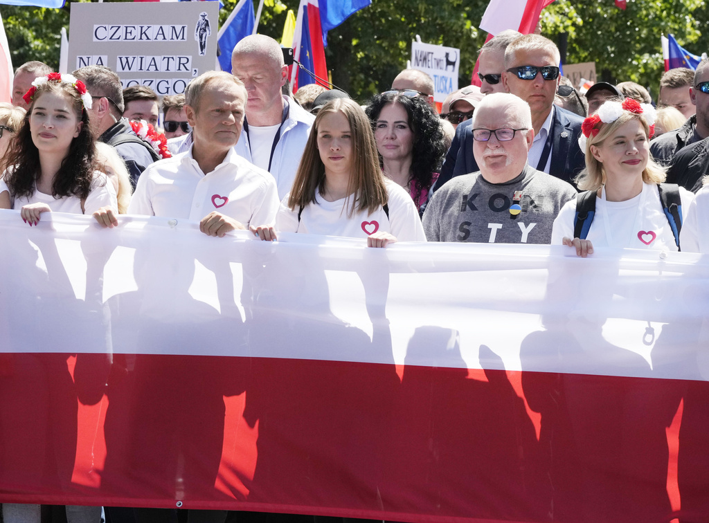 Participants join an anti-government march led by the centrist opposition party leader Donald Tusk, second left, and Lech Walesa, second right, who along with other critics accuse the government of eroding democracy, in Warsaw, Poland, Saturday June 4, 2023. The march is being held on the 34th anniversary of the first democratic elections in 1989 after Poland emerged from decades of communist rule. (AP Photo/Czarek Sokolowski)