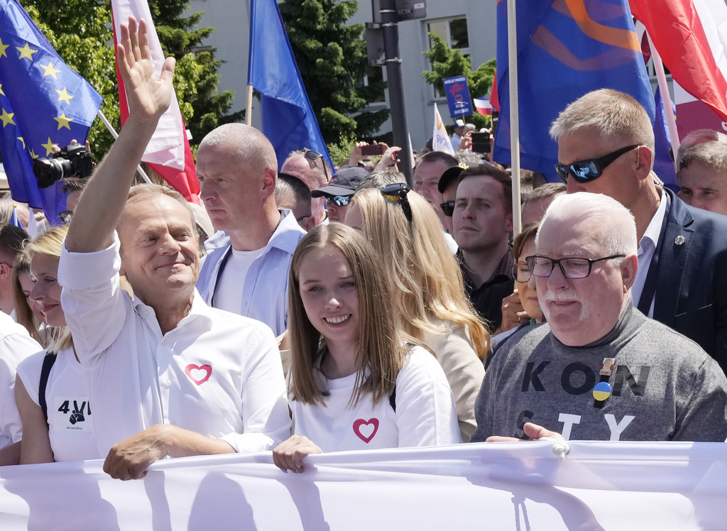 Participants join an anti-government march led by the centrist opposition party leader Donald Tusk, left, and Lech Walesa, right, who along with other critics accuse the government of eroding democracy, in Warsaw, Poland, Saturday June 4, 2023. The march is being held on the 34th anniversary of the first democratic elections in 1989 after Poland emerged from decades of communist rule. (AP Photo/Czarek Sokolowski)