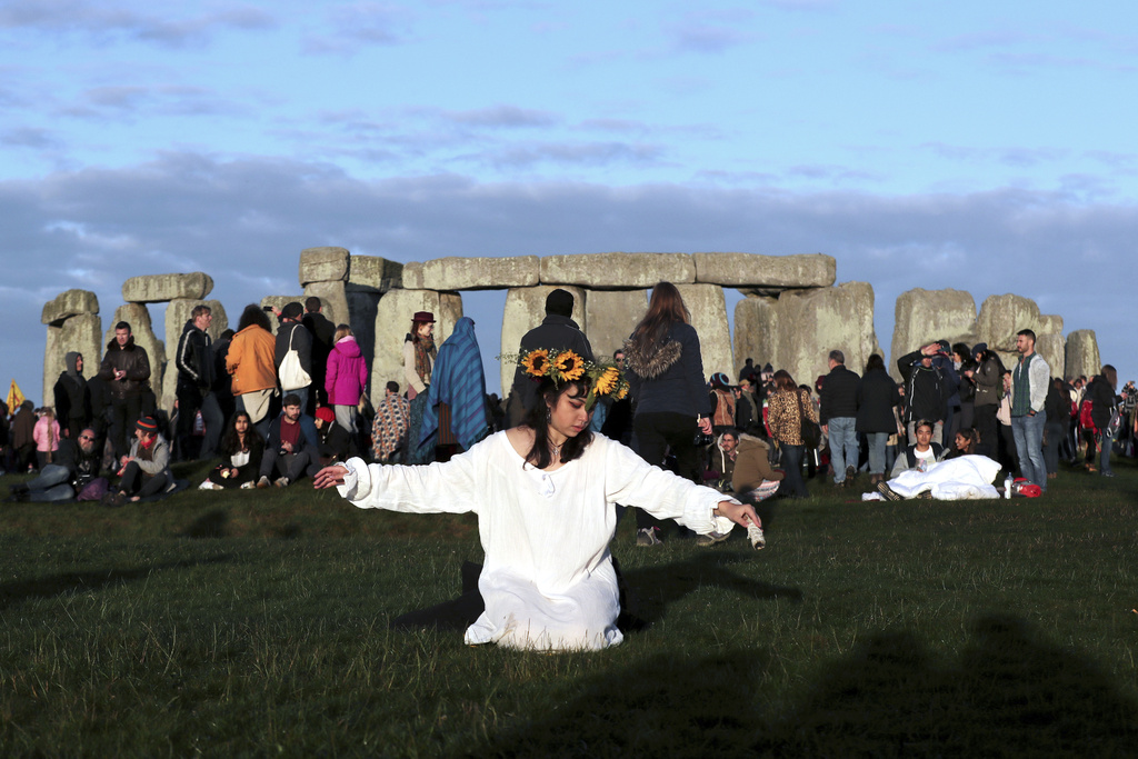 FILE - A reveler prays at sunrise as thousands gather at the ancient stone circle Stonehenge to celebrate the Summer Solstice, the longest day of the year, near Salisbury, England, Friday, June 21, 2019. Druids, pagans, hippies, local residents, tourists and costumed witches and wizards are expected to start gathering Tuesday, June 20, 2023, around a prehistoric stone circle on a plain in southern England to express their devotion to the sun, or to have some communal fun. (AP Photo/Aijaz Rahi, File)