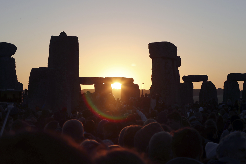 FILE - The sun rises as thousands of revelers gather at the ancient stone circle Stonehenge to celebrate the Summer Solstice, the longest day of the year, near Salisbury, England, Friday, June 21, 2019. Druids, pagans, hippies, local residents, tourists and costumed witches and wizards are expected to start gathering Tuesday, June 20, 2023, around a prehistoric stone circle on a plain in southern England to express their devotion to the sun, or to have some communal fun. (AP Photo/Aijaz Rahi, File)