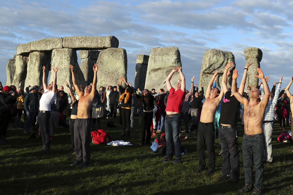 FILE - Revelers perform yoga soon after sun rise at the ancient stone circle Stonehenge to celebrate the Summer Solstice, the longest day of the year, near Salisbury, England, Friday, June 21, 2019. Druids, pagans, hippies, local residents, tourists and costumed witches and wizards are expected to start gathering Tuesday, June 20, 2023, around a prehistoric stone circle on a plain in southern England to express their devotion to the sun, or to have some communal fun. (AP Photo/Aijaz Rahi, File)