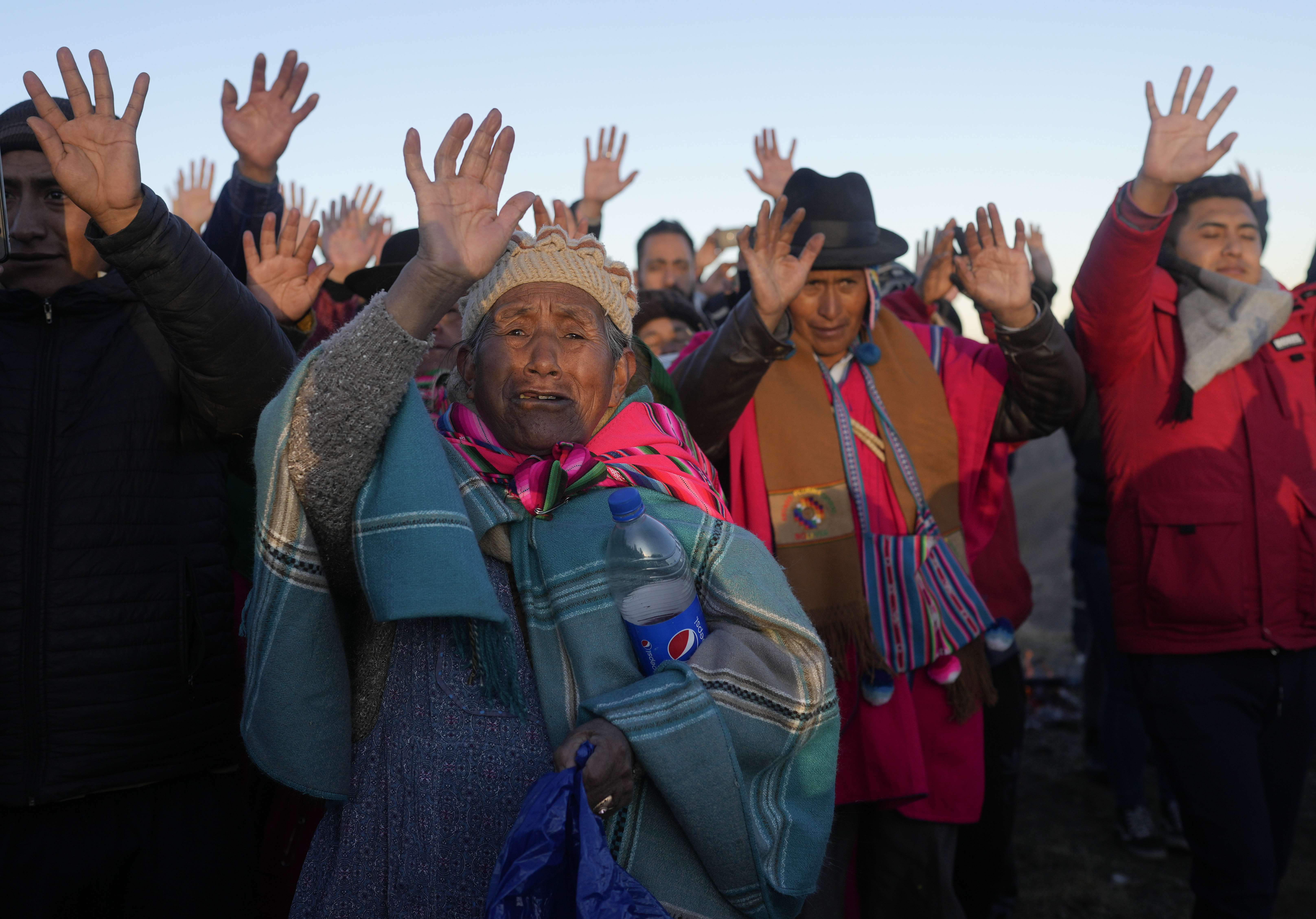 Aymara Indigenous people receive the first rays of sunlight in a New Year's ritual at the sacred mountain Apacheta Murmutani on the outskirts of Hampaturi, Bolivia, early Wednesday, June 21, 2023. Aymara Indigenous communities are celebrating the Andean new year 5,531 or 