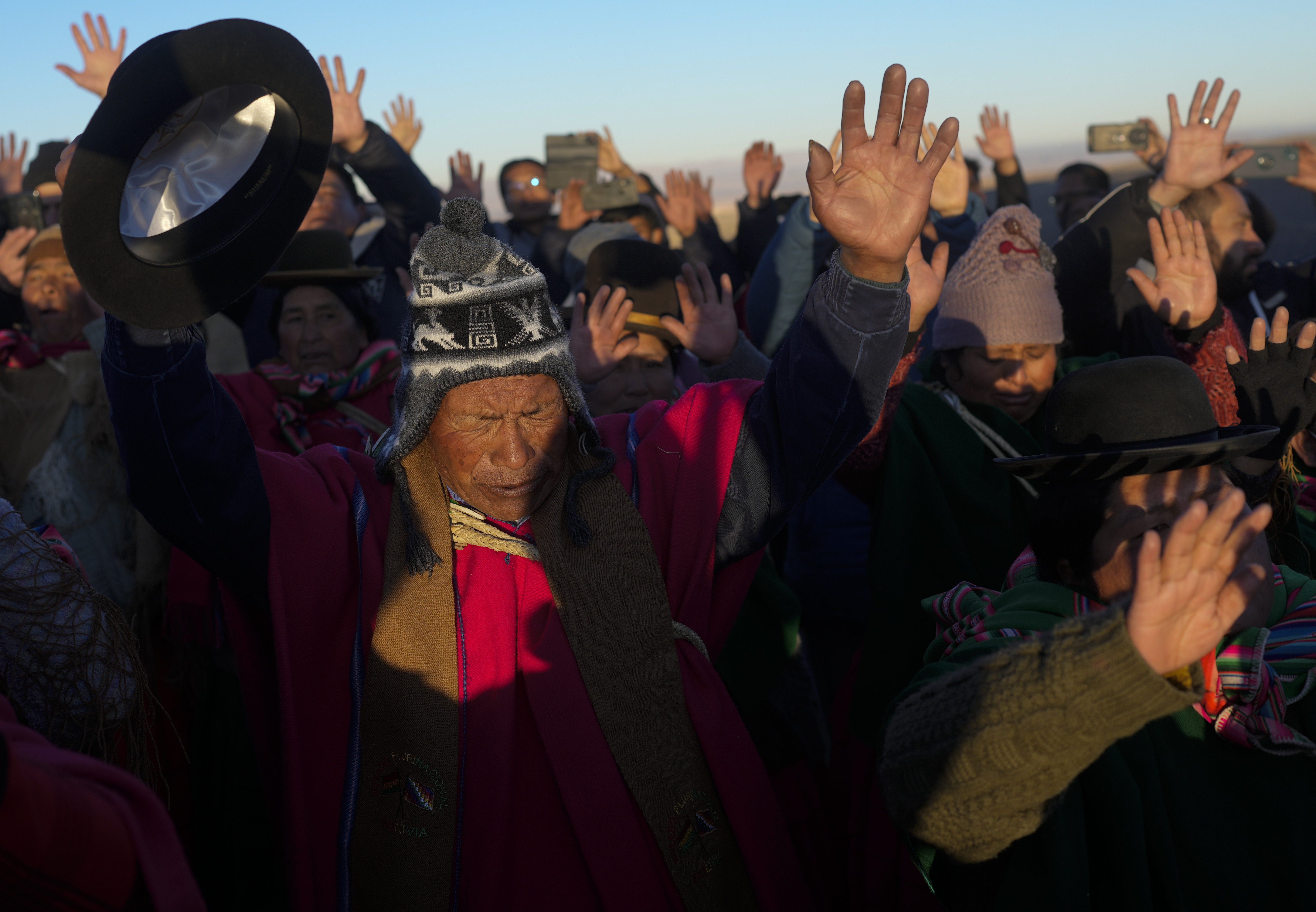 Aymara Indigenous people receive the first rays of sunlight in a New Year's ritual on the sacred mountain Apacheta Murmutani on the outskirts of Hampaturi, Bolivia, early Wednesday, June 21, 2023. Aymara Indigenous communities are celebrating the Andean new year 5,531 or 