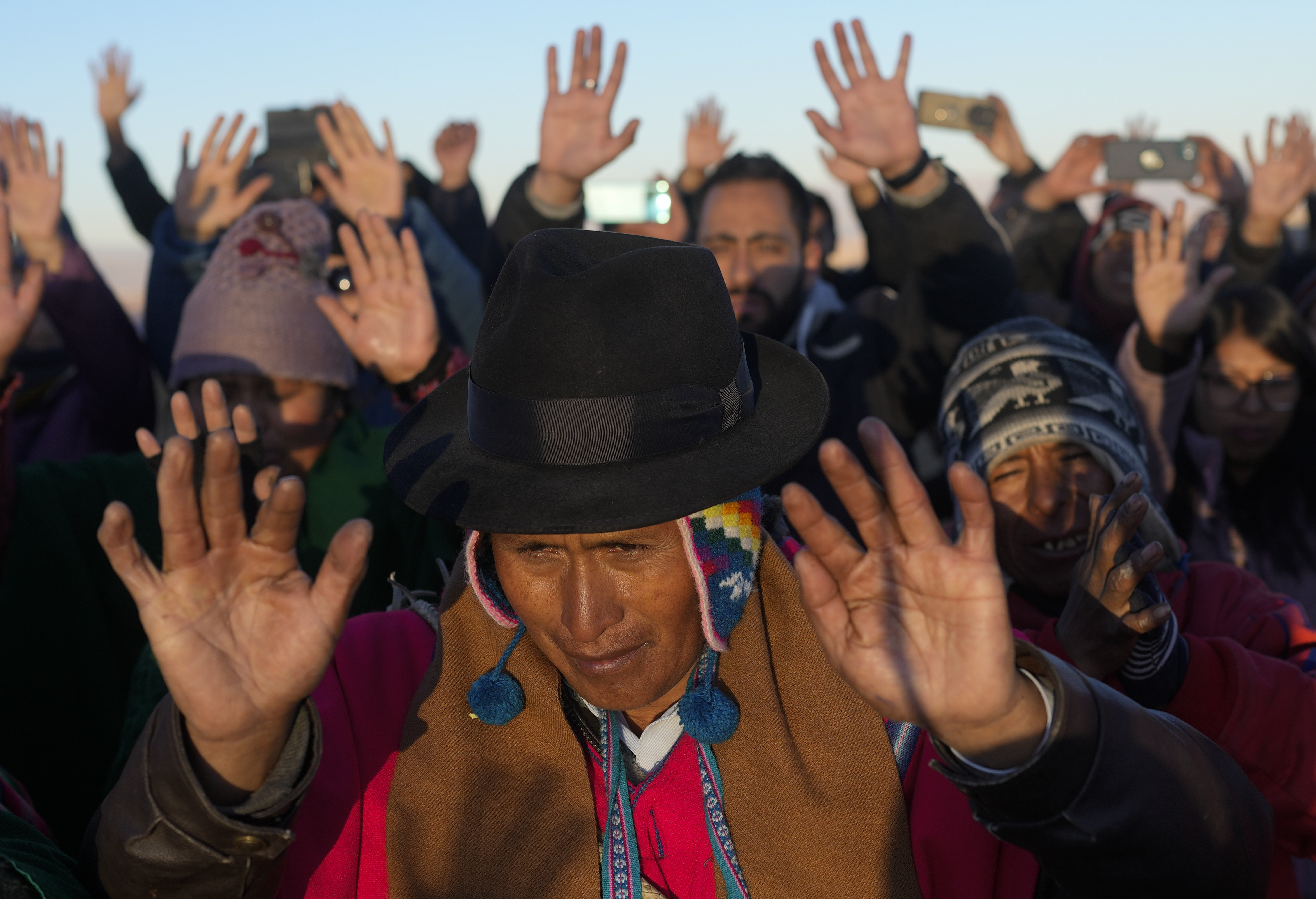 Aymara Indigenous people receive the first rays of sunlight in a New Year's ritual on the sacred mountain Apacheta Murmutani on the outskirts of Hampaturi, Bolivia, early Wednesday, June 21, 2023. Aymara Indigenous communities are celebrating the Andean new year 5,531 or 