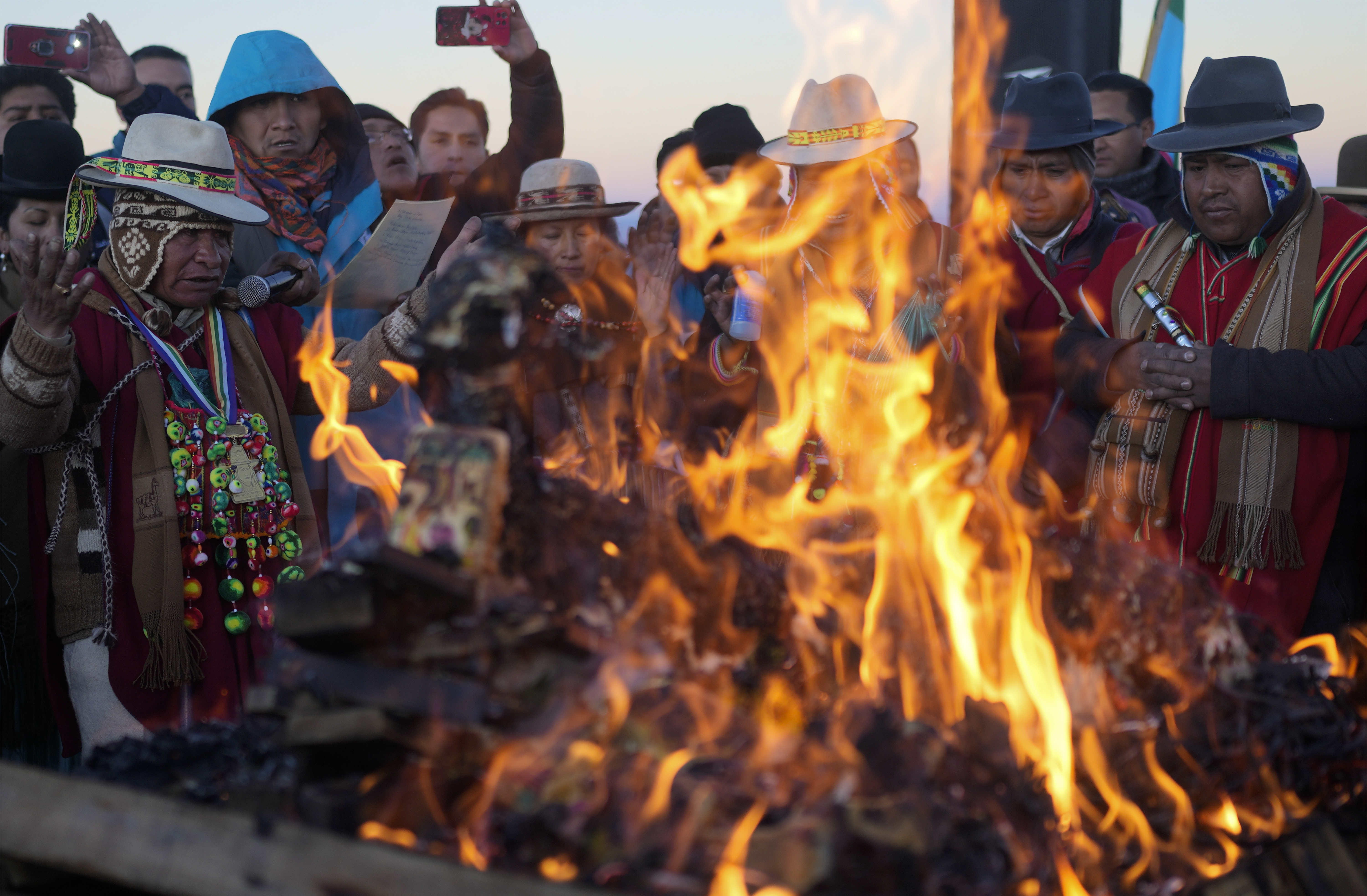 Aymara Indigenous burn offerings in honor of Pachamama or Mother Earth, after receiving the first rays of sunlight in a New Year's ritual on the sacred mountain Apacheta Murmutani on the outskirts of Hampaturi, Bolivia, early Wednesday, June 21, 2023. Aymara Indigenous communities are celebrating the Andean new year 5,531 or 