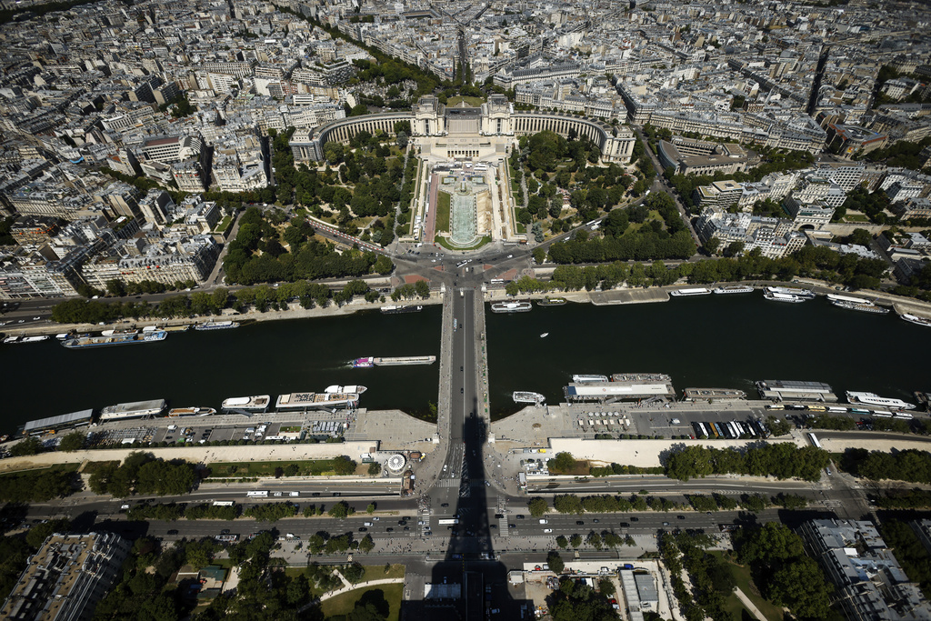 The Eiffel Towers casts its shadow on the Iena bridge, crossing the Seine river and leading to the Trocadero monument, top, Tuesday, July 11, 2023 in Paris. In 2024, (AP Photo/Thomas Padilla)