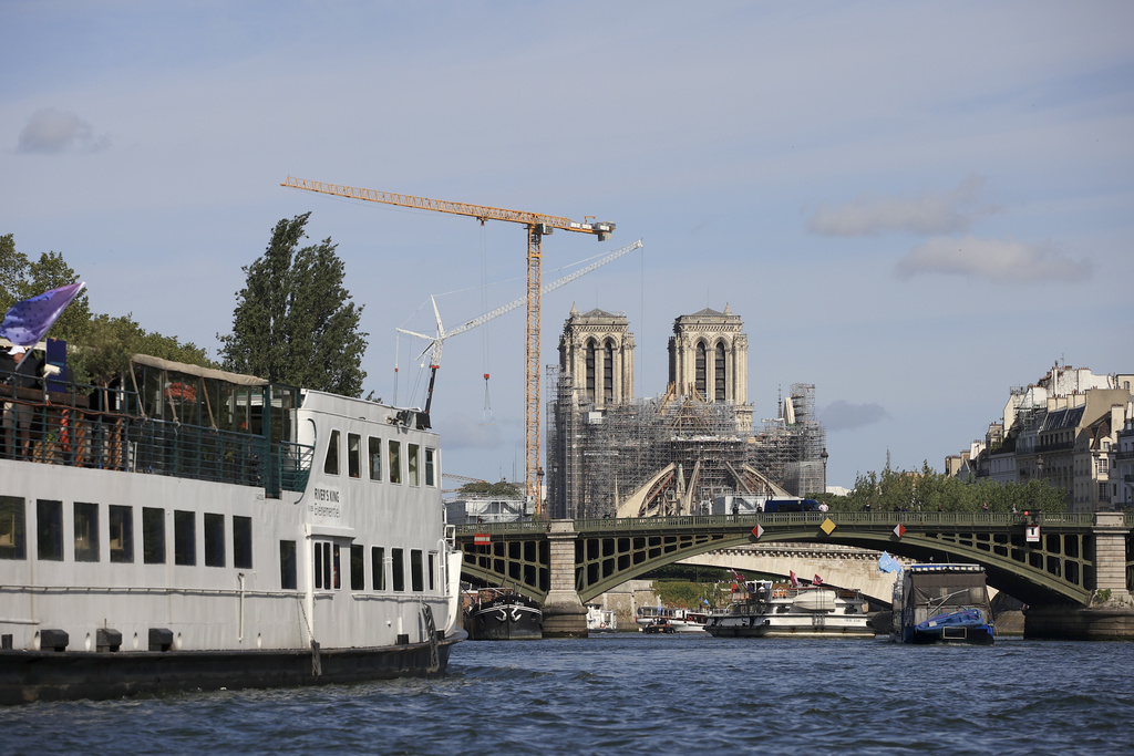 Barges cruise on the Seine river, with Notre-Dame de Paris cathedral in background, during a test for the Paris 2024 Olympic Games opening ceremony, Monday, July 17, 2023 in Paris. Thousands of Olympic athletes on boats will cruise along the River Seine for the Paris 2024 Olympic Games on July 26, 2024.(AP Photo/Aurelien Morissard)