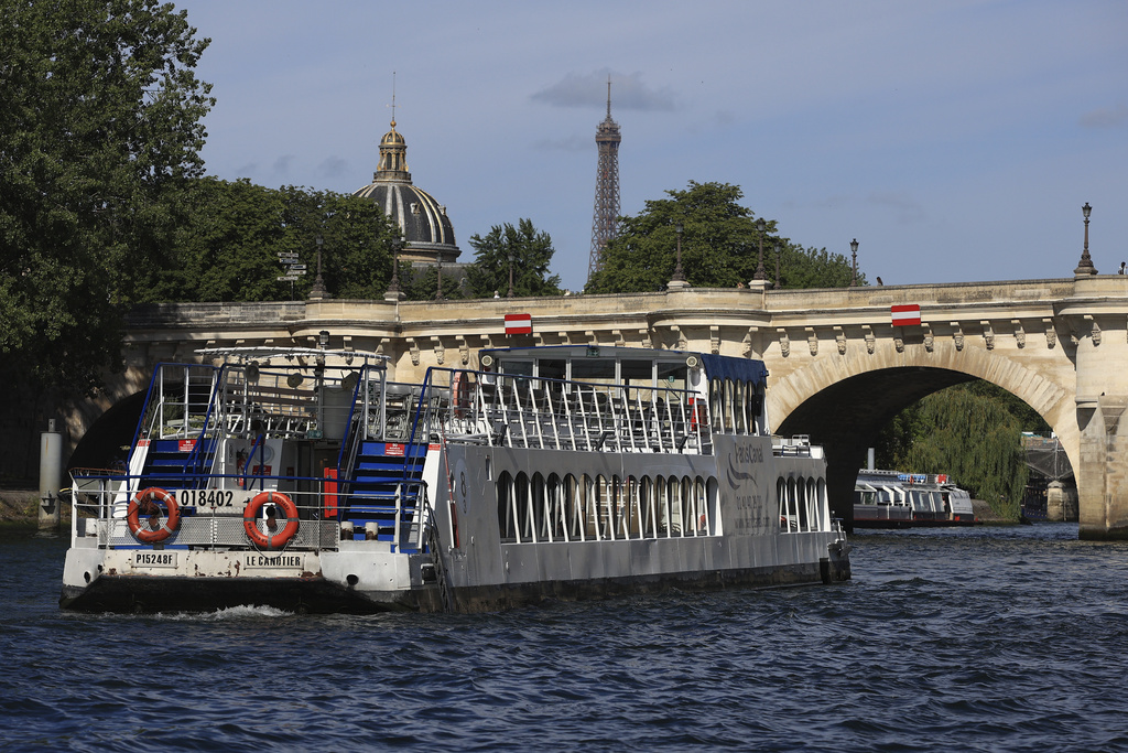 Barges cruise on the Seine river, with the Eiffel Tower in background, during a test for the Paris 2024 Olympic Games opening ceremony, Monday, July 17, 2023 in Paris. Thousands of Olympic athletes on boats will cruise along the River Seine for the Paris 2024 Olympic Games on July 26, 2024.(AP Photo/Aurelien Morissard)