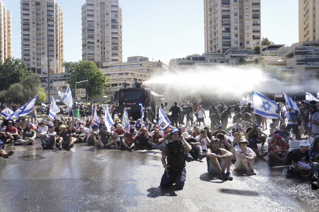 Israeli police disperse demonstrators blocking the road leading to the Knesset, Israel's parliament, during a protest against plans by Prime Minister Benjamin Netanyahu's government to overhaul the judicial system, in Jerusalem, Monday, July 24, 2023. The demonstration came hours before parliament is expected to vote on a key part of the plan. (AP Photo/Mahmoud Illean)