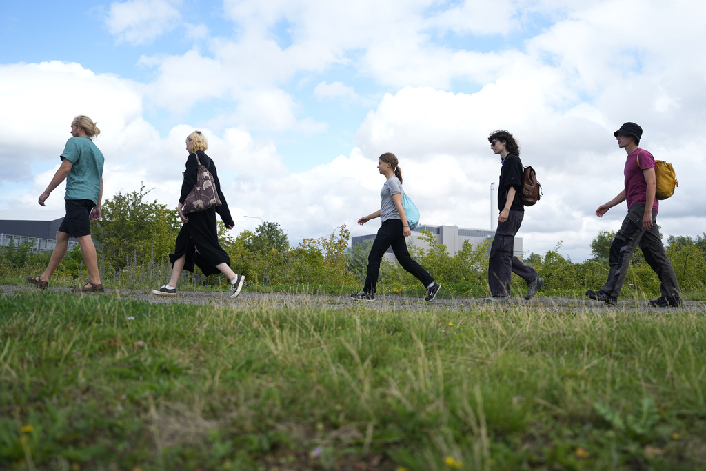 Greta Thunberg, centre, and other activists walk to block the entrance to an oil facility in Malmo, Sweden, Monday, July 24, 2023. The protest took place just a few hours after Thunberg was fined for disobeying police during a similar protest last month at the same terminal. (AP Photo/Pavel Golovkin)