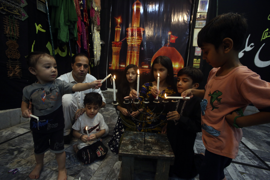 People participate and light candles in the Ashoura procession at Imam Bargah in Peshawar, Pakistan, Sunday, July 23, 2023. Ashoura, marks the tenth day of the Muslim month of Muharram, to commemorate the Battle of Karbala when Imam Hussein, a grandson of Prophet Muhammad, was killed in the 7th century. (AP Photo/Mohammad Sajjad)