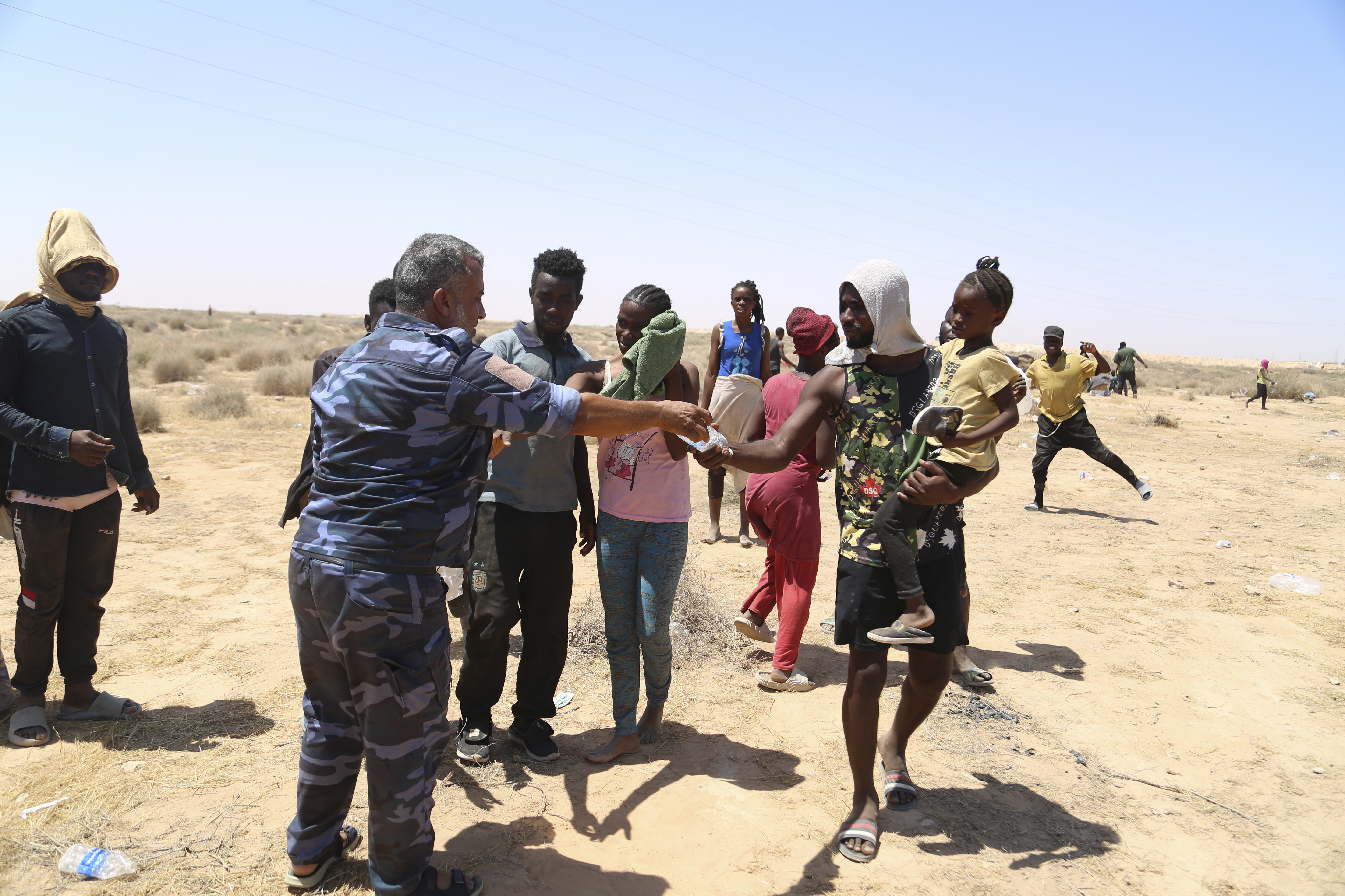 Libyan policeman gives water to African migrants on the Libyan border with Tunisia on Thursday, Aug. 4, 2023. The Tunisian security forces reportedly expelled hundreds of migrants over the border into Libya, where they have been stranded in scorching summer temperatures without water and food since June. (AP Photo/Yousef Murad)


Associated Press/LaPresse
Only Italy and Spain