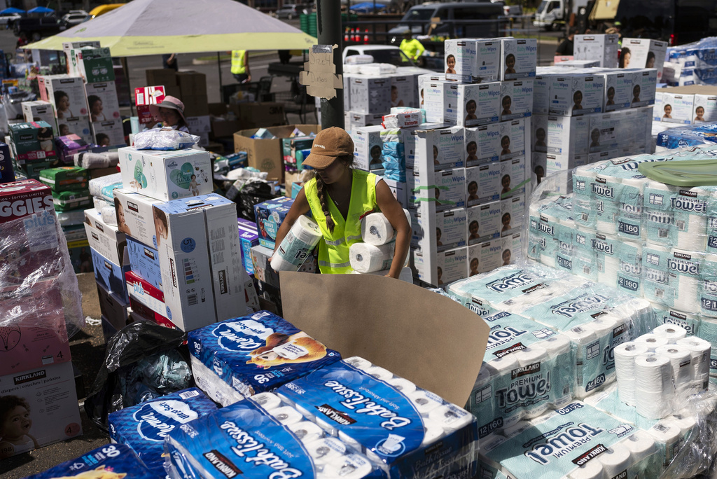 A volunteers works at a food and supply distribution center set up in the parking lot of a shopping mall in Lahaina, Hawaii, Wednesday, Aug. 16, 2023, after wildfires devastated parts of the Hawaiian island of Maui. (AP Photo/Jae C. Hong)