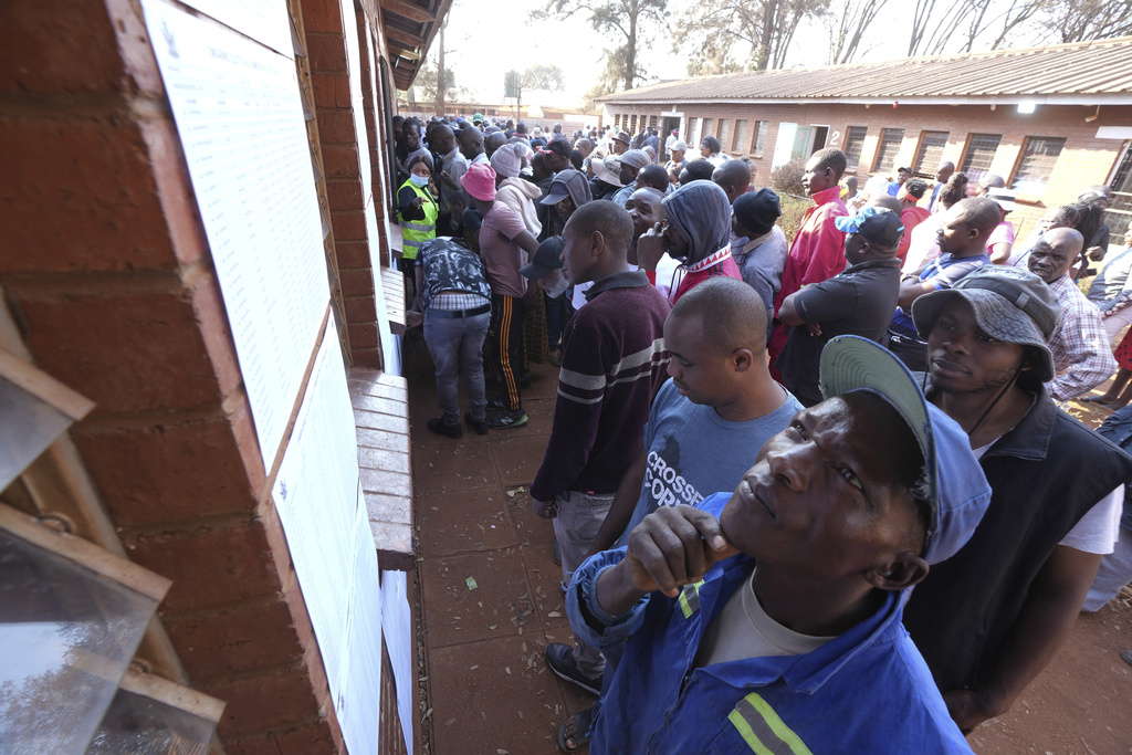 A man looks for his name on a list outside a polling station in Harare, Wednesday, Aug. 23 2023. Polls opened in Zimbabwe on Wednesday as President Emmerson Mnangagwa seeks a second and final term in a country with a history of violent and disputed votes. (AP Photo/Tsvangirayi Mukwazhi)