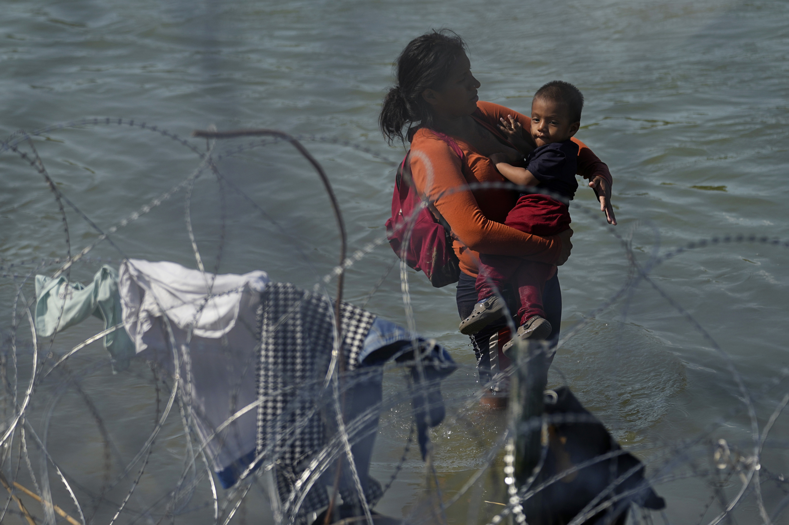 Migrants who crossed into the U.S. from Mexico are met with concertina wire along the Rio Grande, Thursday, Sept. 21, 2023, in Eagle Pass, Texas. (AP Photo/Eric Gay)