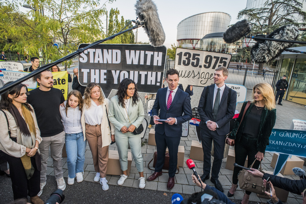 IMAGE DISTRIBUTED FOR AVAAZ -  Director of the Global Legal Action Network Gearoid O Cuinn, centre, and members of the global civic movement Avaaz gather in front of the European Court of Human Rights with messages of support from around the world for the 6 applicants in the 