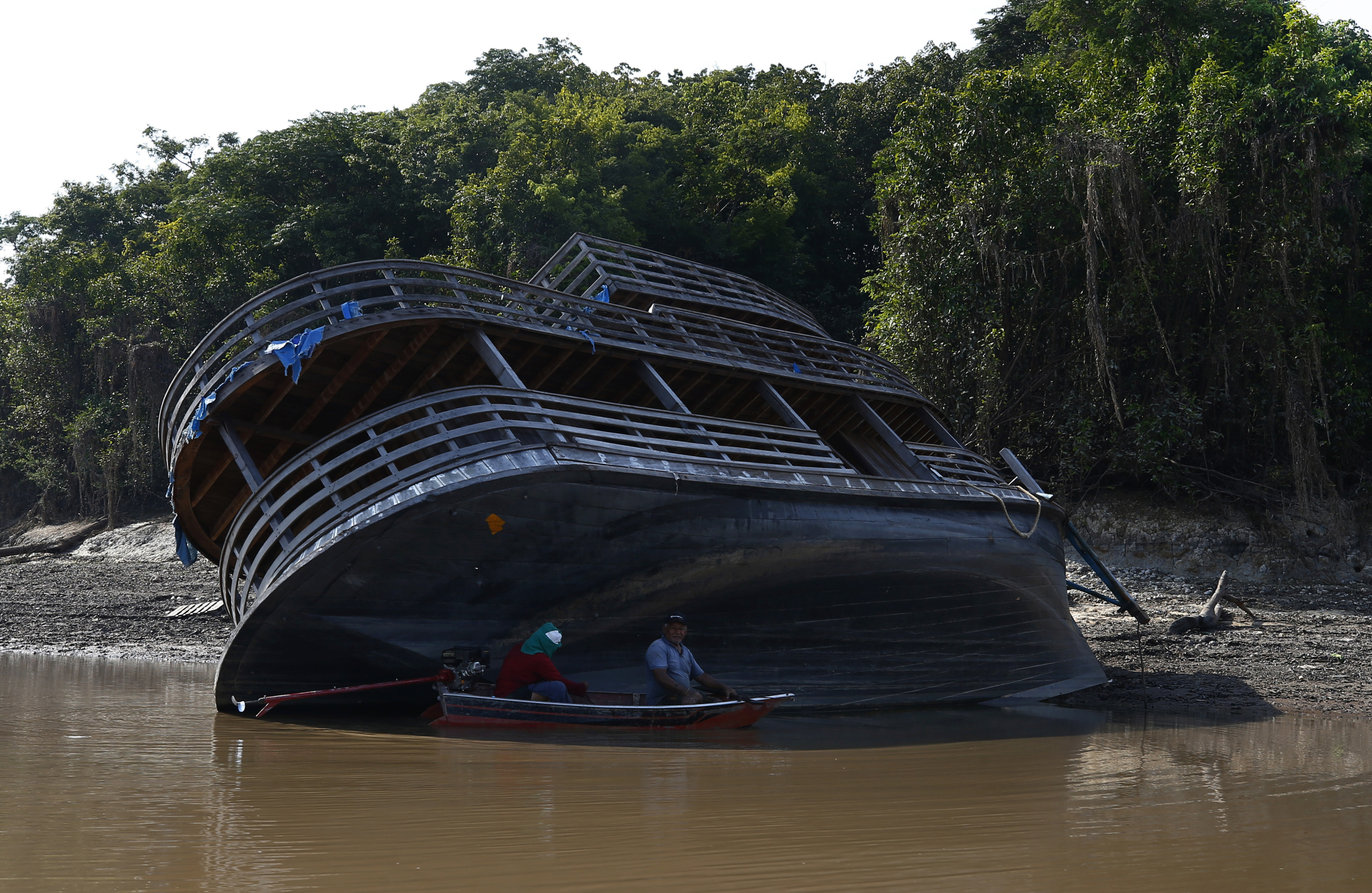 Fishermen take cover from the sun next to a riverboat that ran aground in the dried-out Puraquequara lake amid a severe drought, in Manaus, Amazonas state, Brazil, Thursday, Oct. 5, 2023. The Brazilian Amazon rainforest is facing a severe drought that may affect around 500,000 people by the end of the year. (AP Photo/Edmar Barros)Associated Press/LaPresseOnly Italy and Spain