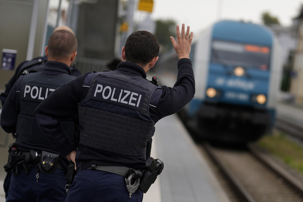 German federal police officers gesture towards a train driver near a border crossing point between Germany and Czech Republic at the station in Furth am Wald, Germany, Tuesday, Oct. 10, 2023. (AP Photo/Matthias Schrader)