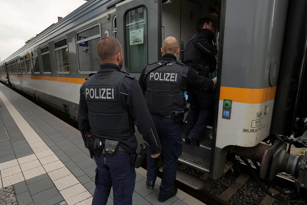 German federal police officers board a train near a border crossing point between Germany and Czech Republic at the station in Furth am Wald, Germany, Tuesday, Oct. 10, 2023. The police officers check the travelers' IDs. (AP Photo/Matthias Schrader)