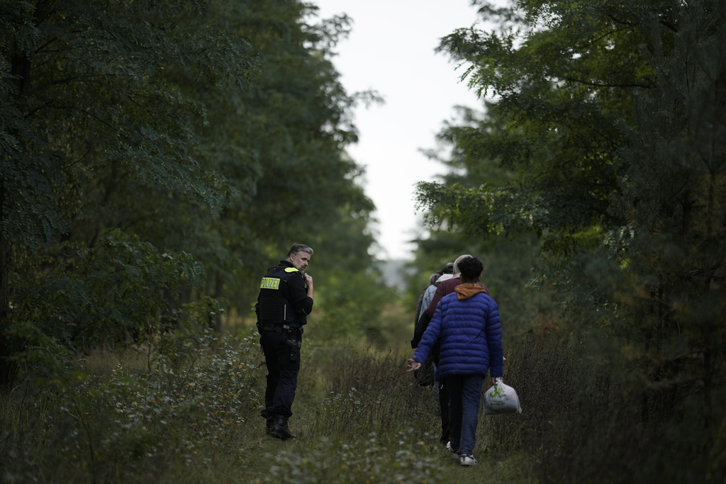 FILE - Police officer Frank Malack escorts a group of migrants who illegally crossed the border from Poland into Germany during a patrol in a forest near Forst southeast of Berlin, Germany, Wednesday, Oct. 11, 2023. Germany on Monday, Oct. 16, 2023 notified the European Union's executive branch of border controls at its frontiers with Poland, the Czech Republic and Switzerland, going a step beyond a move last month to strengthen checks on its eastern border. (AP Photo/Markus Schreiber, File)