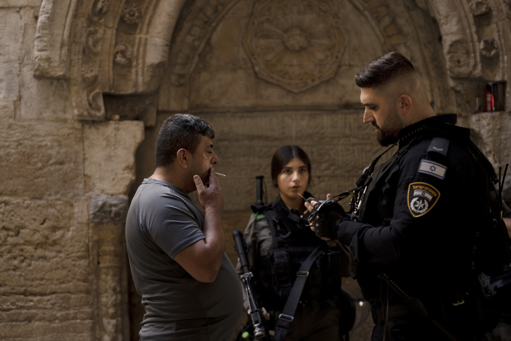 Israeli police check a Palestinian worshipper's ID ahead of Friday prayers at the Al-Aqsa Mosque compound in the Old City of Jerusalem, Friday, Oct. 13, 2023 as tens of thousands of Muslims demonstrated across the Middle East in support of the Palestinians and against the intensifying Israeli bombardment of Gaza. At the Al-Aqsa Mosque in Jerusalem's Old City, Israeli police were permitting only certain older men, women and children to enter the sprawling hilltop compound for prayers, trying to limit the potential for violence. Only 5,000 worshippers made it into the site, the Islamic endowment that manages the mosque said. On a typical Friday, some 50,000 perform the prayers. (AP Photo/Maya Alleruzzo)