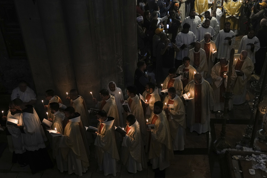 Priests participate in the Easter Sunday Mass led by the Latin Patriarch of Jerusalem Pierbattista Pizzaballa, at the Church of the Holy Sepulcher, where many Christians believe Jesus was crucified, buried and rose from the dead, in the Old City of Jerusalem, Sunday, April 9, 2023. (AP Photo/Mahmoud Illean)