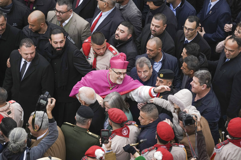Latin Patriarch Pierbattista Pizzaballa greets worshippers in Manger Square, adjacent to the Church of the Nativity, traditionally believed to be the birthplace of Jesus Christ, in the West Bank town of Bethlehem during Christmas, Saturday , Dec. 24, 2022. (AP Photo/Mahmoud Illean)