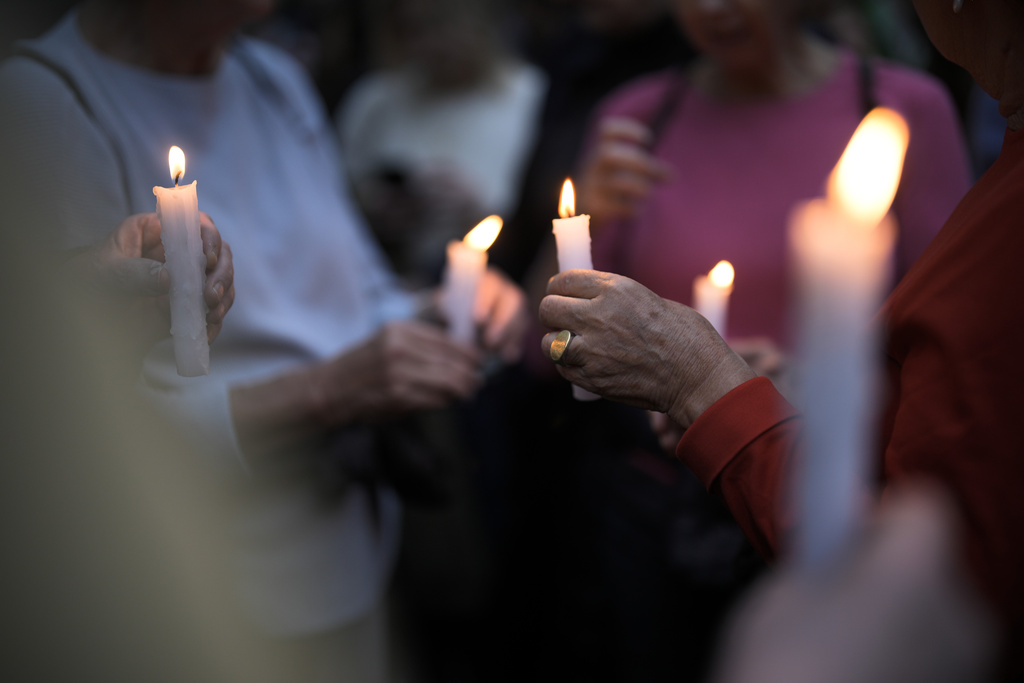 People hold candles as they attend a vigil in front of a synagogue in Berlin, Germany, Friday, Oct. 13, 2023. Hundreds of Berliners assembled in front of the Fraenkelufer Synagogue, on the eve of Shabbat to protect it and the prayer service held inside from possible attacks. (AP Photo/Markus Schreiber)
