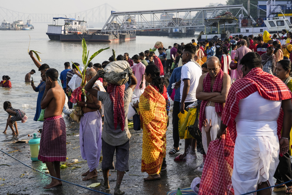 Hindu priests and devotees gather on the banks of the Hooghly River to perform rituals on the first day of Durga Puja festival in Kolkata, India, Saturday, Oct. 21, 2023. The five-day festival commemorates the slaying of a demon king by goddess Durga, marking the triumph of good over evil. (AP Photo/Bikas Das)