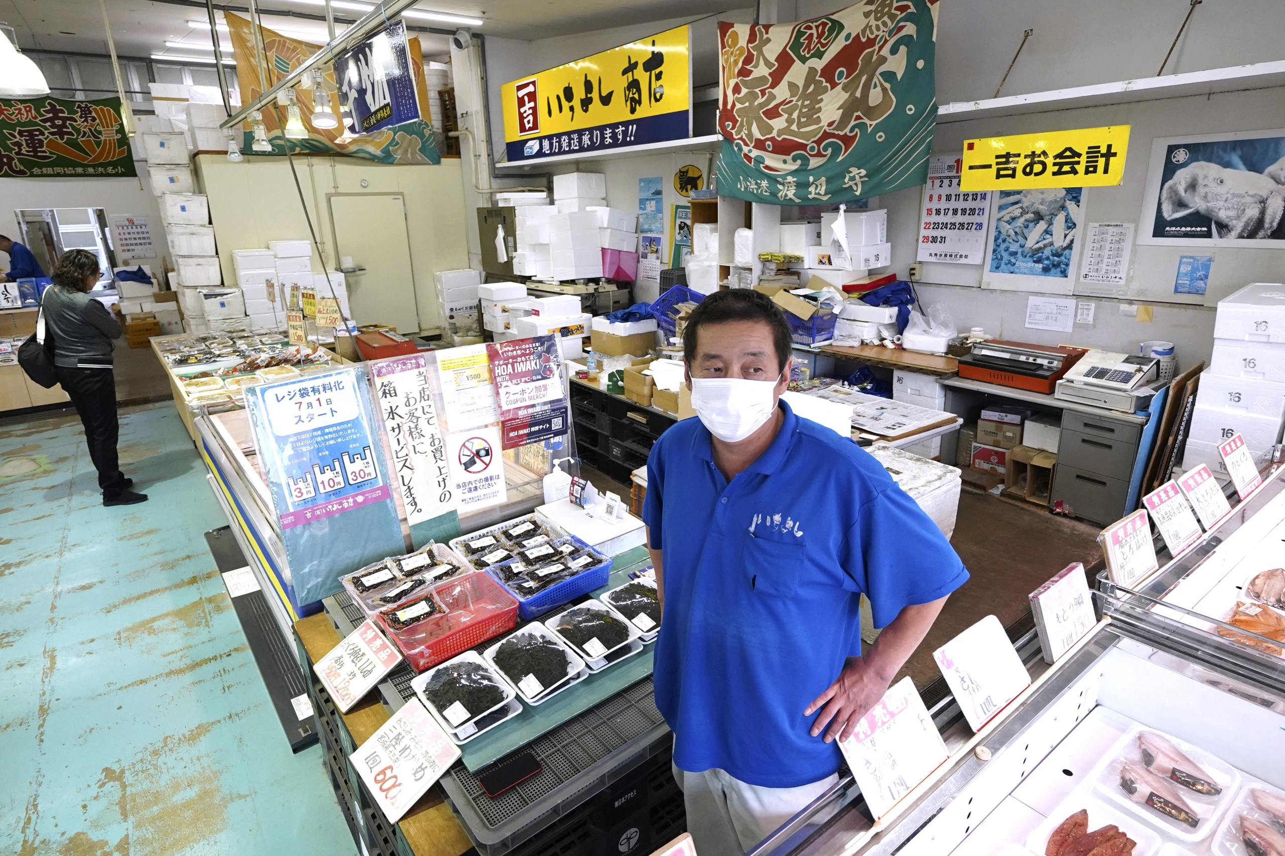 Ichiyoshi fish store manager Hiroharu Haga speaks during an interview with The Associated Press at the seafood market 