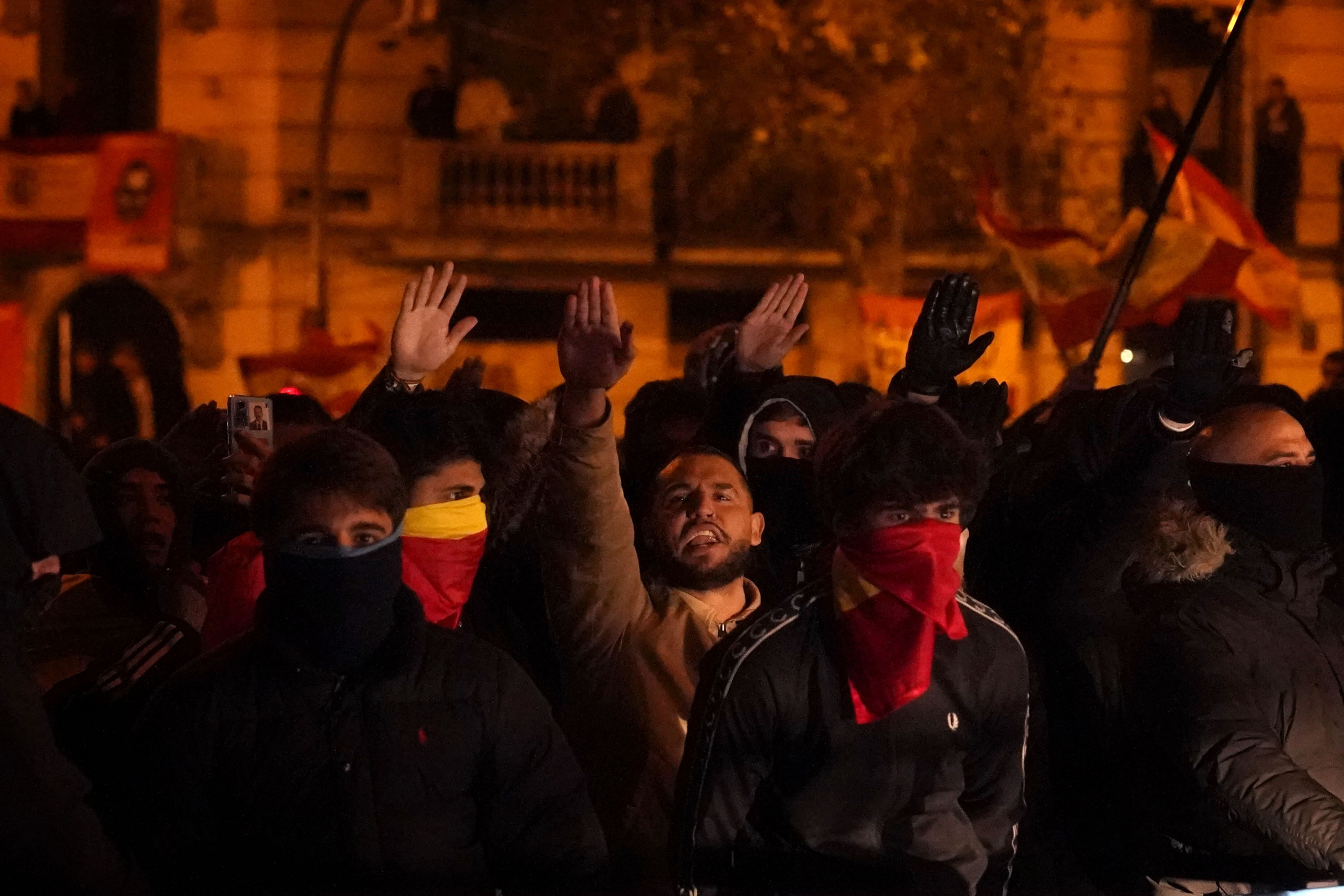 Demonstrators raise their right arm making the fascist salute as they protest against the amnesty at the headquarters of Socialist party in Madrid, Spain, Thursday, Nov. 9, 2023. Protests backed by Vox party turned on Thursday night as Spain's Socialists to grant amnesty to Catalan separatists in exchange for support of new government. (AP Photo/Andrea Comas)